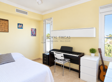 Dormitorio moderno con piano y balcón luminoso