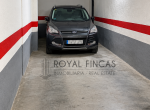 Garaje subterráneo con SUV y marca inmobiliaria